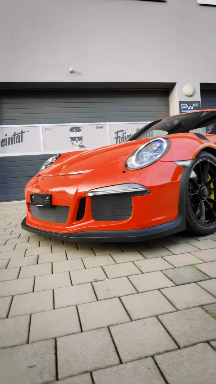 Porsche GT3 RS in Lava Orange vor der Werkstatt von Rheintal Foliendienst